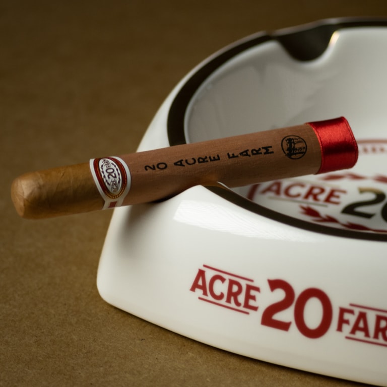 a 20 ACRE FARM cigar over an ashtray