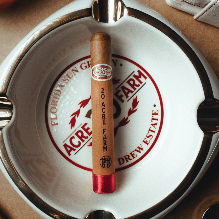 a 20 ACRE FARM cigar over an ashtray