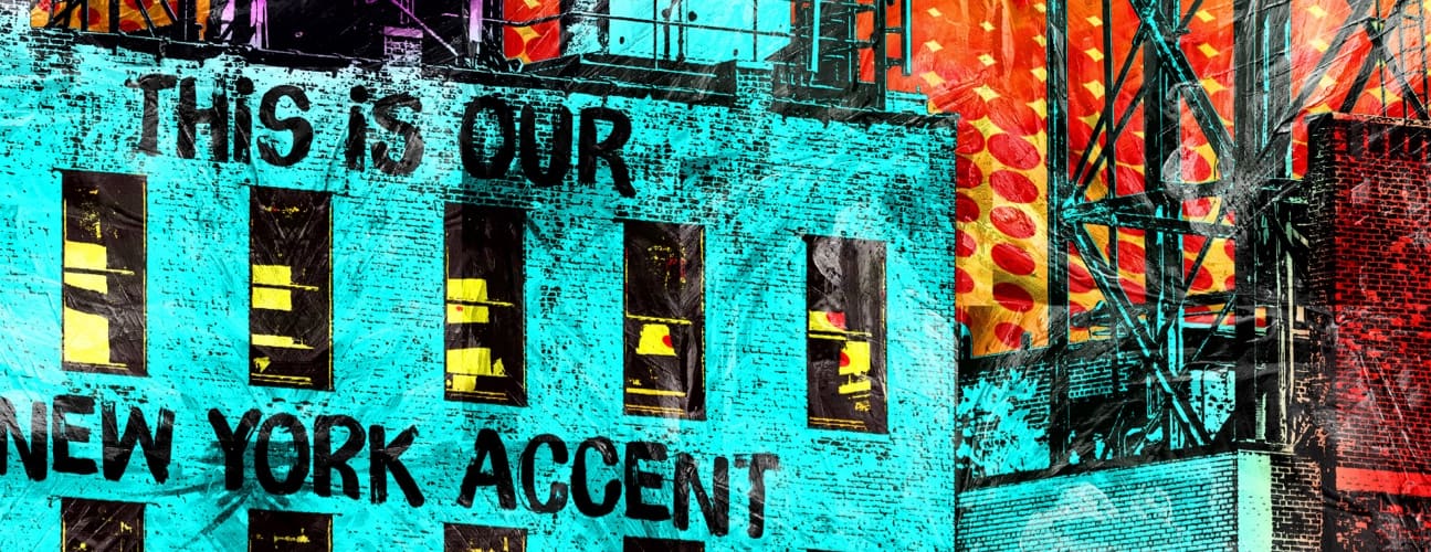 Colorful graffiti on a building facade reads "This is our New York accent," with vibrant red and orange patterns in the background.