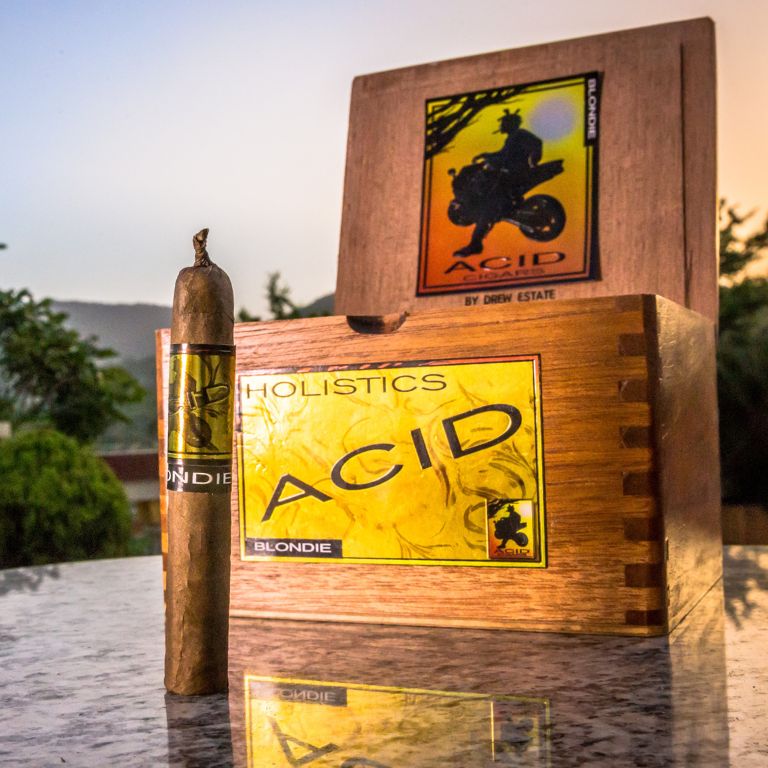 Three acid gold cigars elegantly placed on a polished wooden table