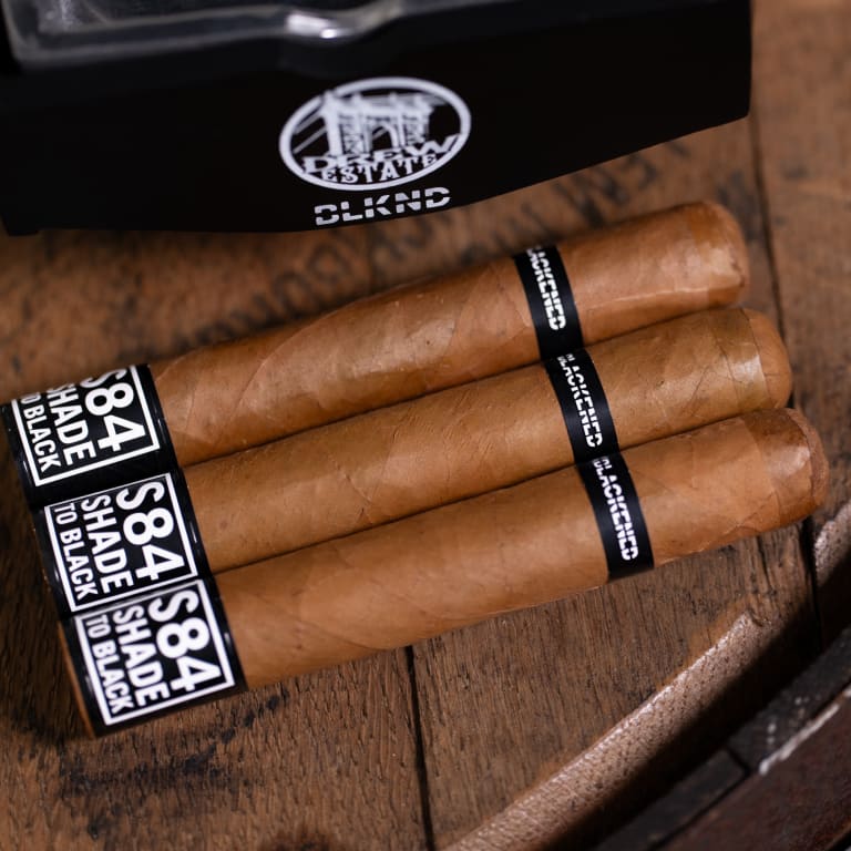 3 blackened shade S84 cigars on a wooden surface
