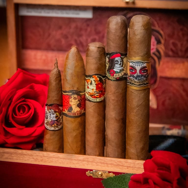 An assortment of Deadwood cigars in a wooden box, with a vibrant rose positioned in the middle