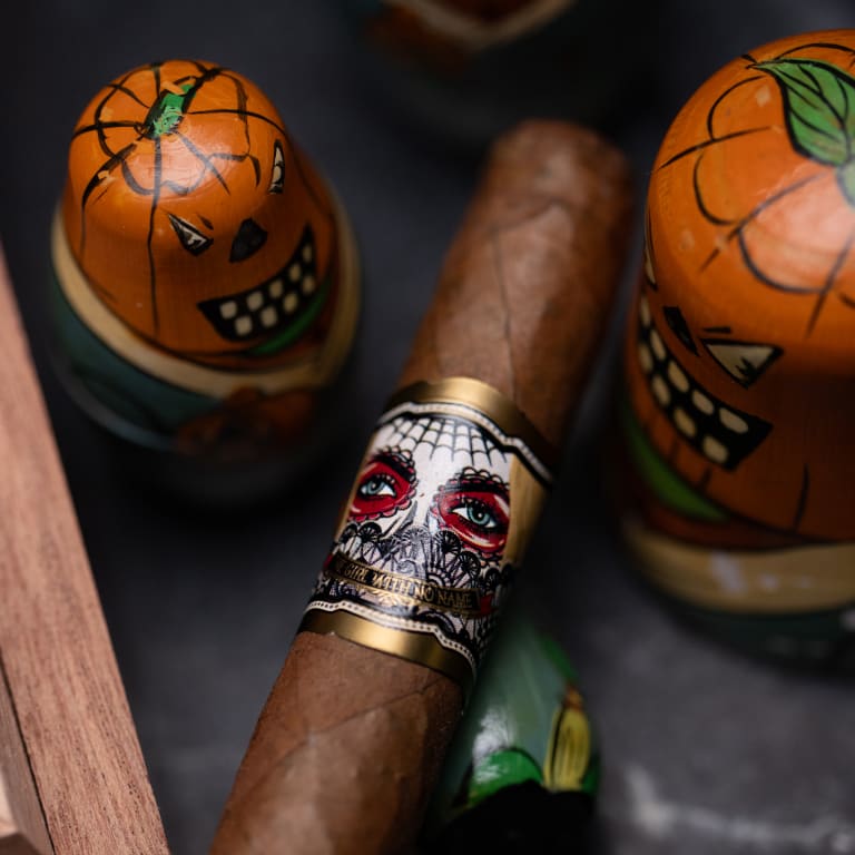 A Deadwood Sweet Jane cigar lies beside a skull and pumpkins