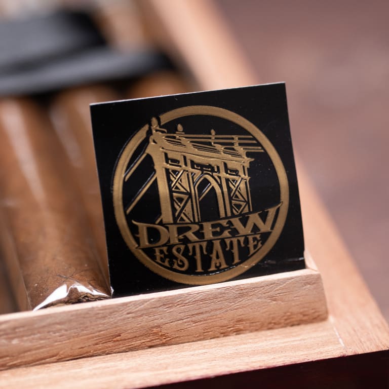 A cigar box featuring a Drew Estate logo prominently displayed on its surface