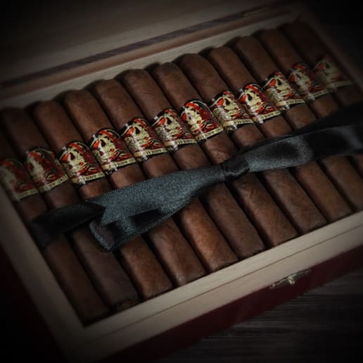 a group of Deadwood Sweet Jane cigars tied in a ribbon in a box