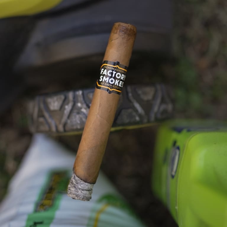 Factory Smokes cigar on a lawnmower