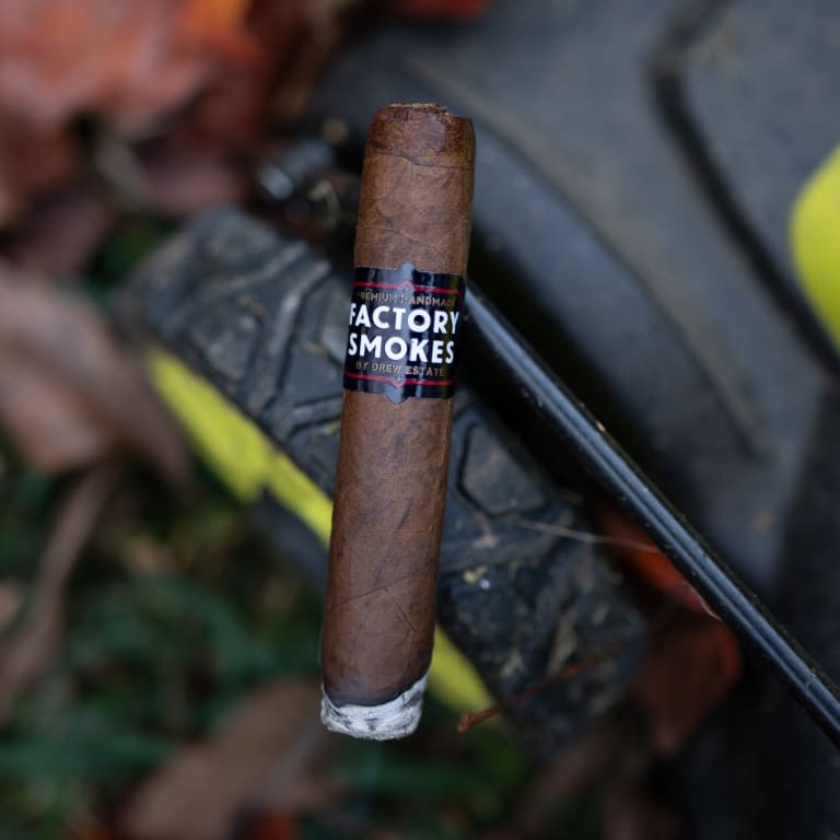 Factory Smokes cigar on a lawnmower