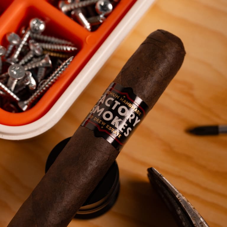 Factory Smokes cigar hover a table with some tools