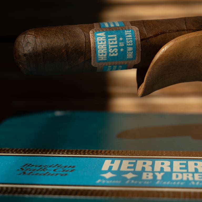 Herrera Esteli Brazil cigar leaning on its side, prominently displaying the elegant label