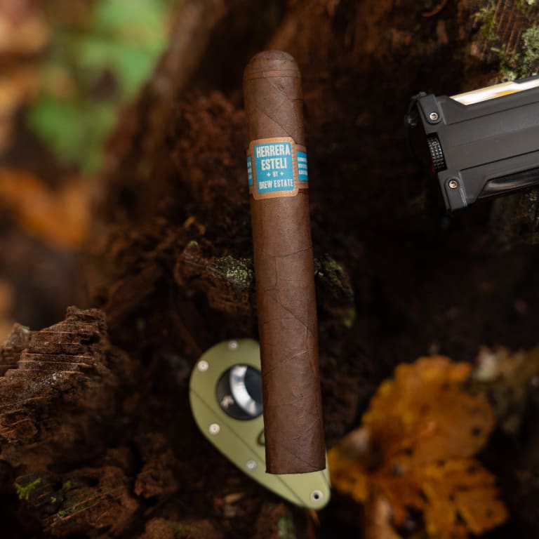 A herrera esteli cigar resting on a tree branch