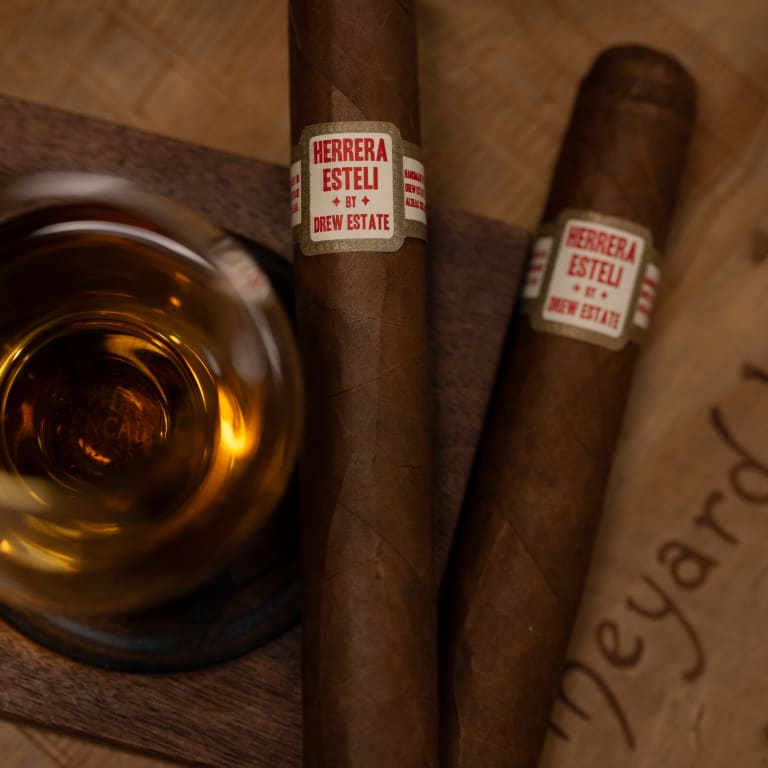 2 herrera esteli habano cigars by a glass of whiskey
