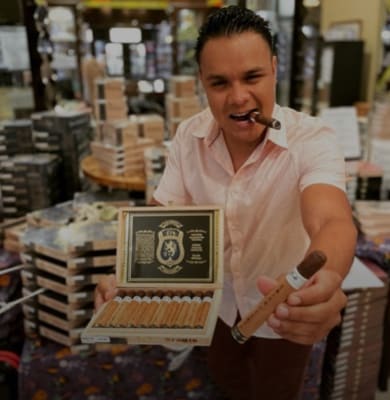 a man posing holding a cigar case and cigar