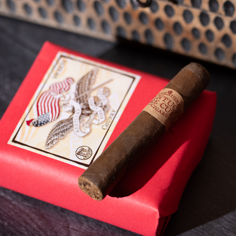 kentucky fire cured sweet cigar resting on a red box