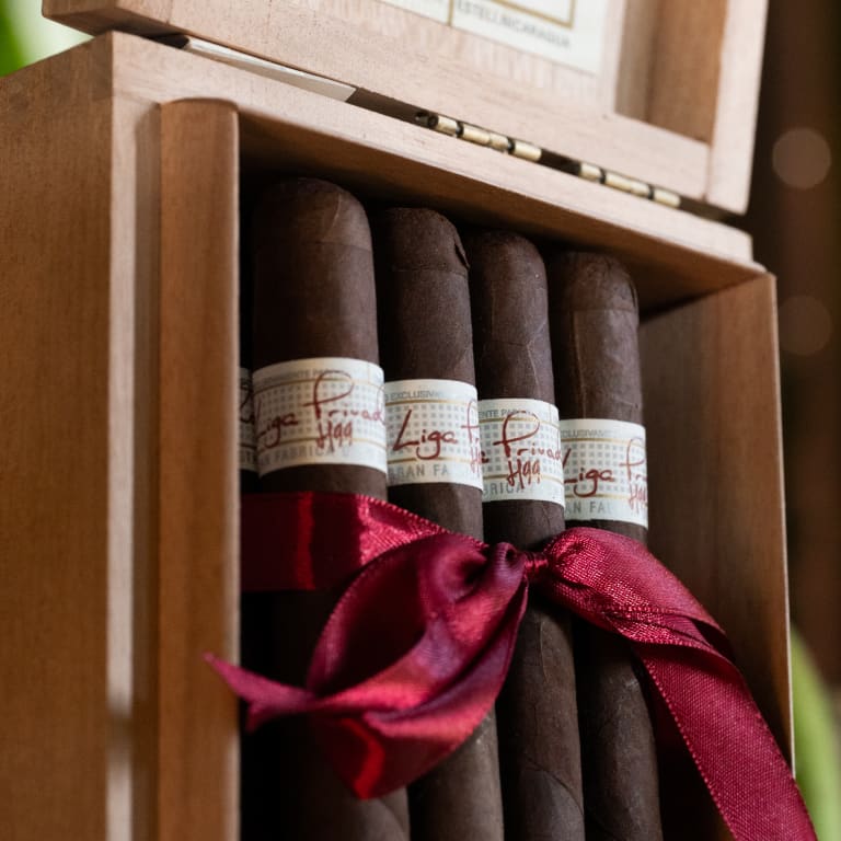 box of liga privada h99 cigars wrapped in a red ribbon