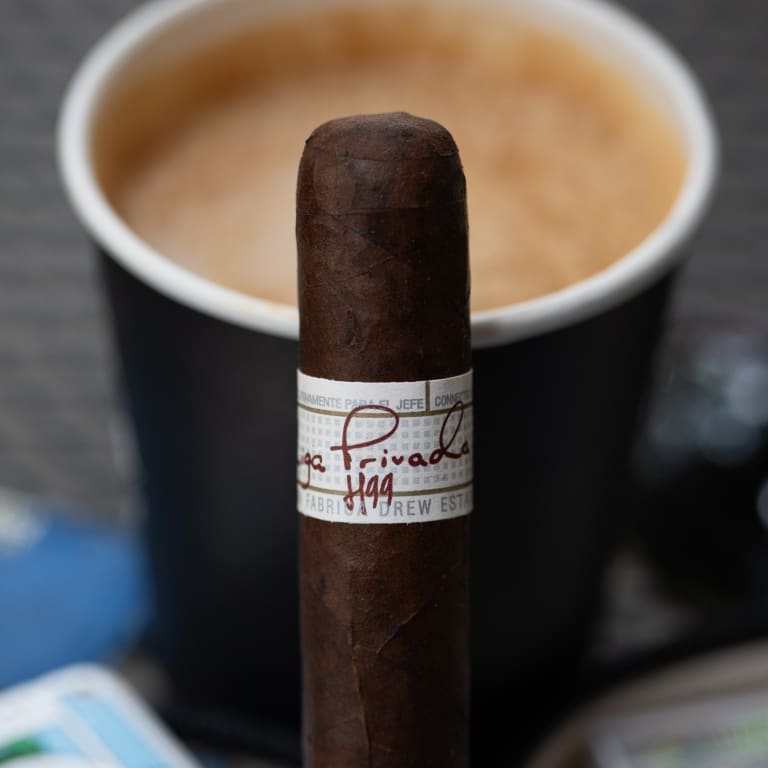 liga privada h99 cigar in front of acup of coffee