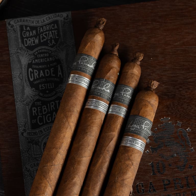 4 Liga Privada cigars rest on a wooden surface with Drew Estate branding