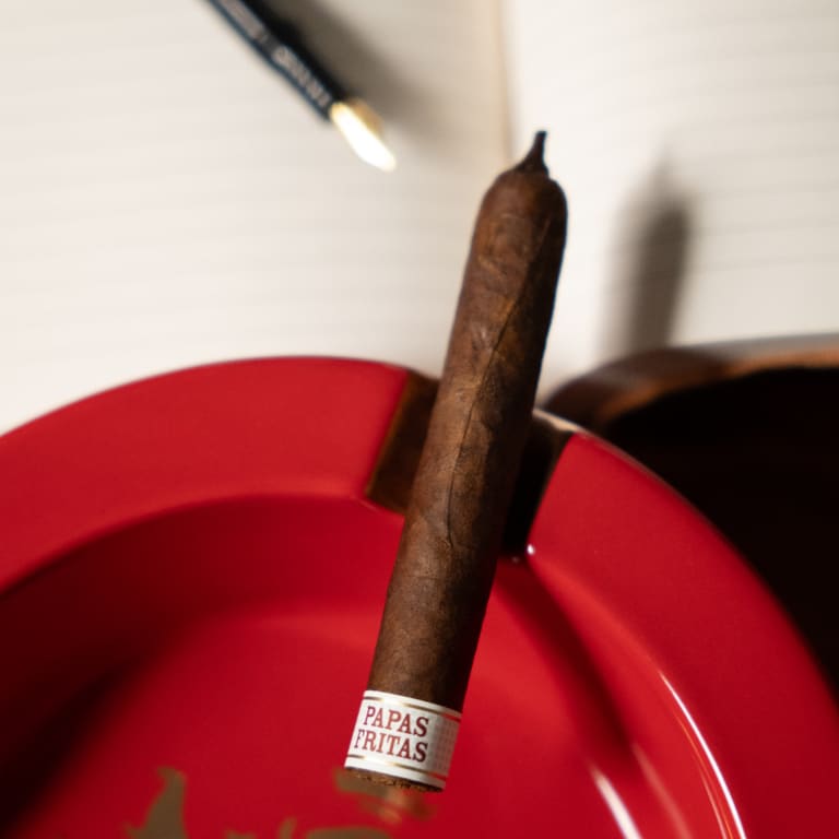 Liga privada Papas Fritas cigar over a red ashtray