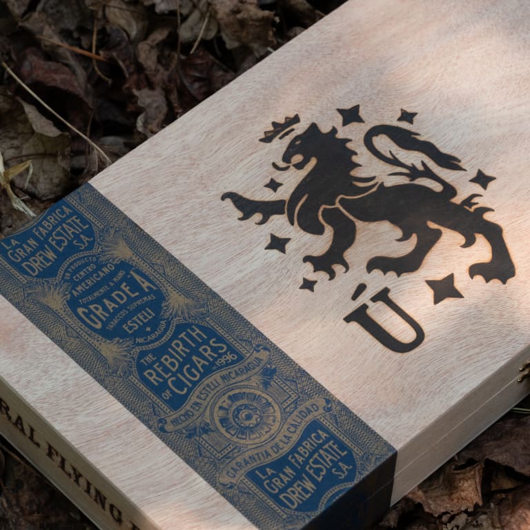 A wooden Liga Privada Unico cigar box featuring an intricately carved lion design on its surface