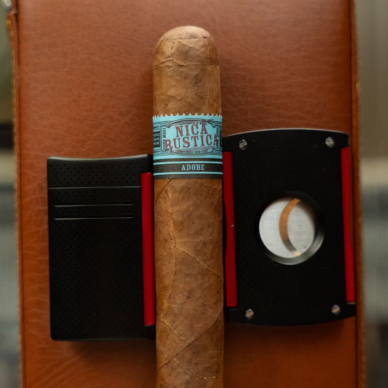 nica rustica adobe cigar over a leather case and a cigar cutter