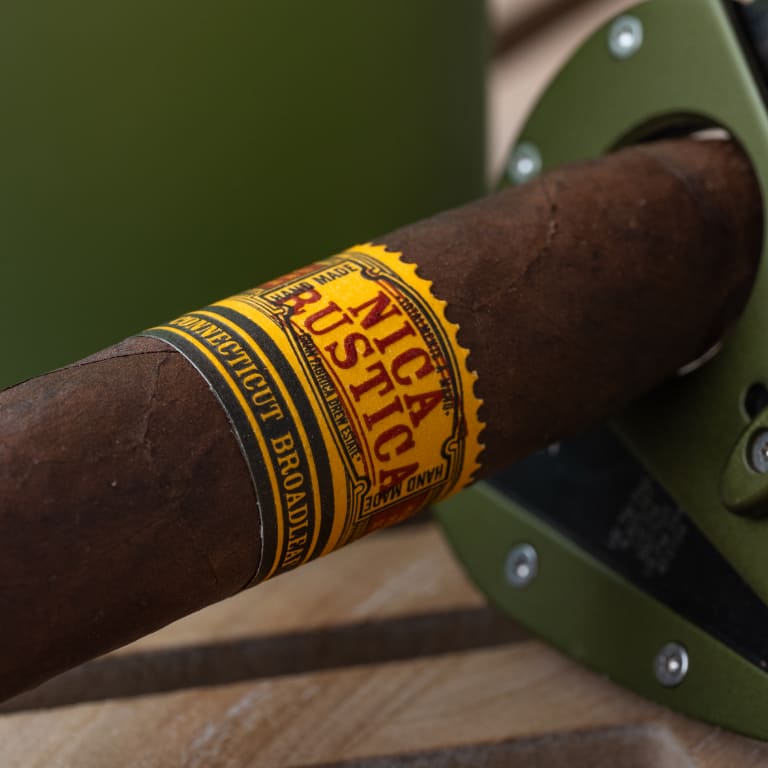A Nica Rustica Broadleaf cigar featuring a distinctive yellow label, elegantly displayed against a neutral background