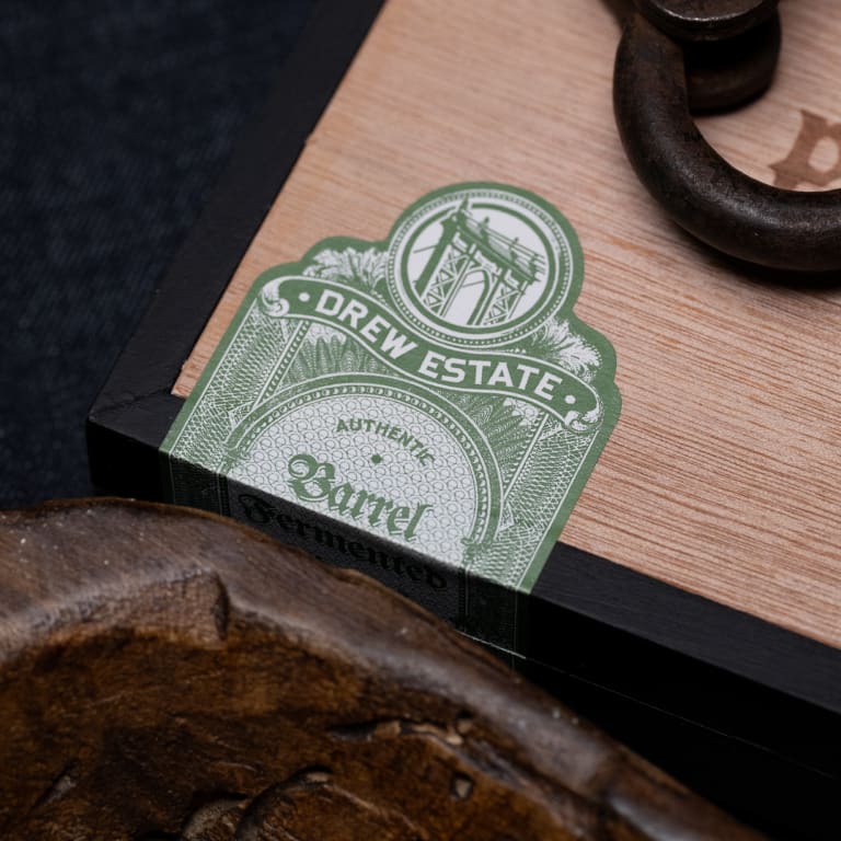 A wooden box featuring a prominent drew estate sticker label affixed to its surface