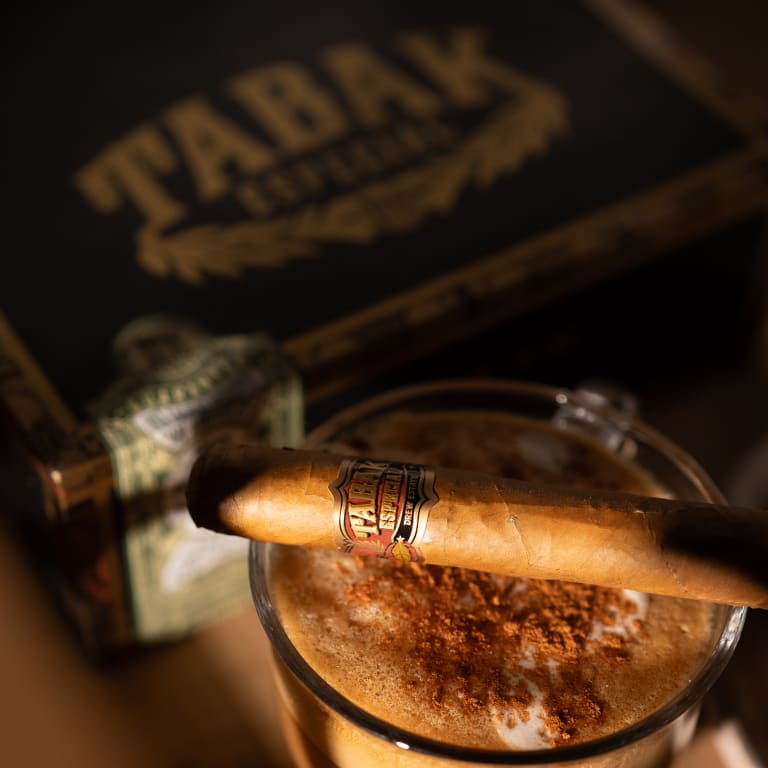 tabak especial cigar on a cup of coffee by a box labeled, "Tabak Especial"