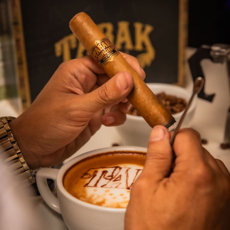 tabak especial cigar held over a cup of coffee