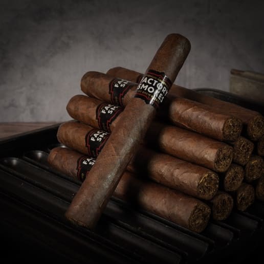 A collection of Factory Smokes Maduro cigars arranged atop a wood surface