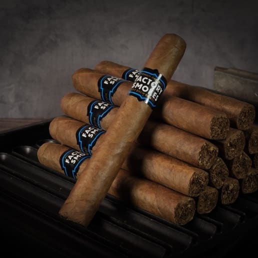 A collection of Factory Smokes Sun Grown cigars arranged atop a grill
