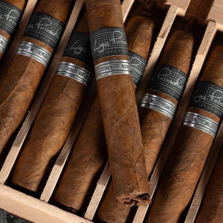 A box of Liga Privada cigars elegantly placed on a polished wooden table, showcasing its rich texture and craftsmanship.