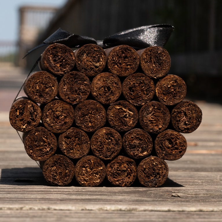 a group of Liga Privada cigars tied with a black ribbon seen from one side