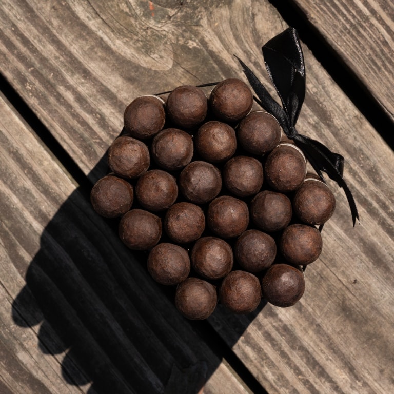 a group of Liga Privada cigars tied with a black ribbon seen from above