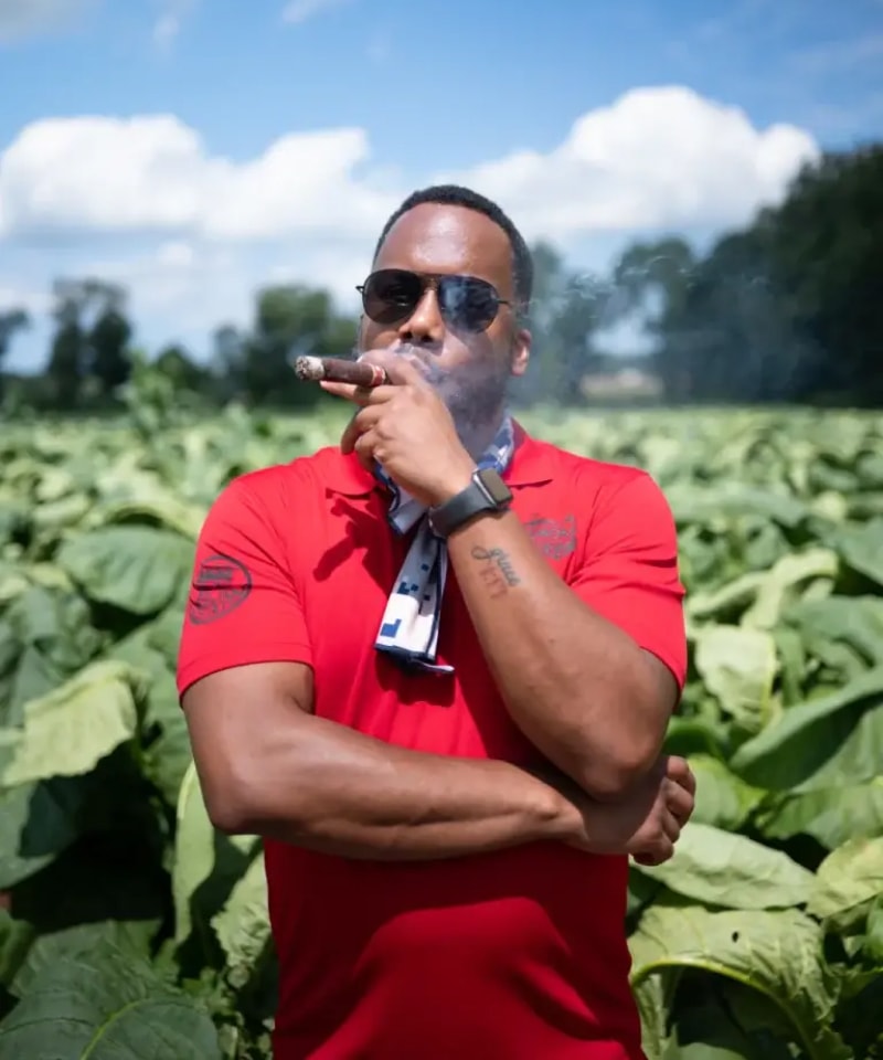 a person smoking a cigar in a tobacco plantation