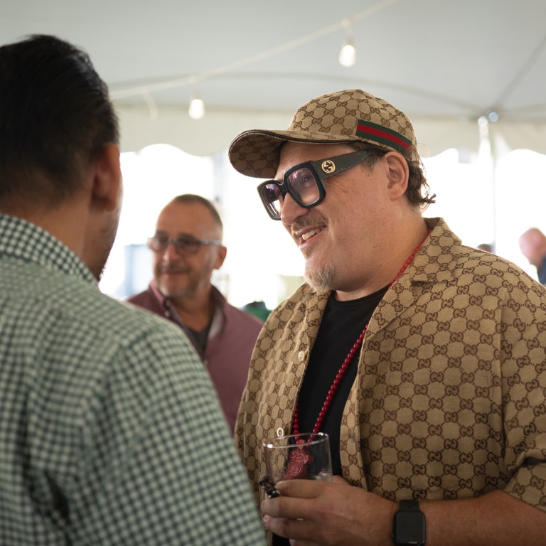 Candid moment at the Kentucky Castle Family Reunion showing 2 attendees talking with JD, enjoying the event under festive lighting