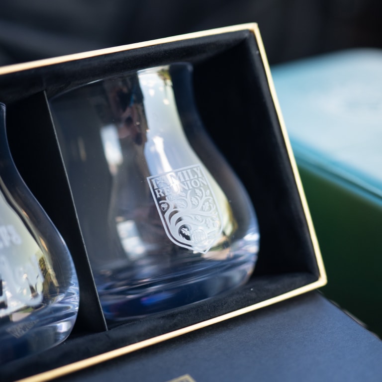 Close-up of two engraved glasses in a black and gold box, with one glass reading 'FAMILY REUNION'—a keepsake from the Kentucky Castle Family Reunion.