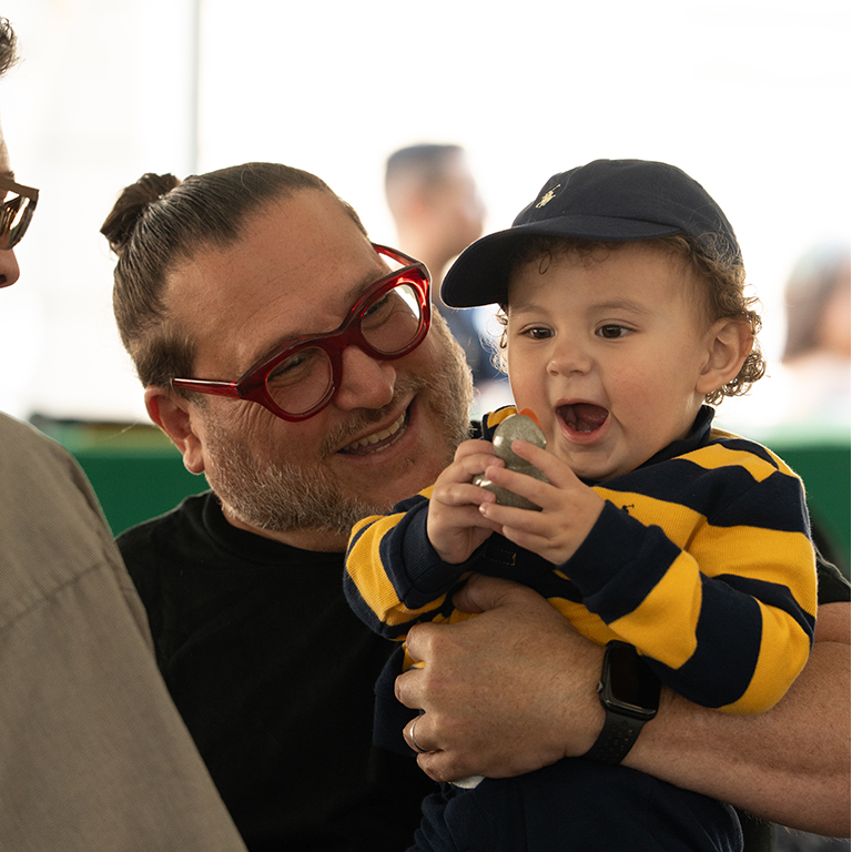 Participants at the Kentucky Castle Family Reunion at the registration desk in a grand room with ornate decor, chandeliers, and a mirrored wall.